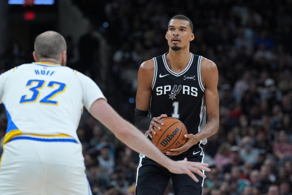 San Antonio Spurs forward Victor Wembanyama (1) looks to shoot against Indiana Pacers center Jay Huff (32) as he watches his shot during the first half of an NBA basketball game in San Antonio, Saturday, March 21,2026. (AP Photo/Eric Gay)