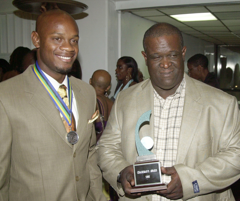 FILE - Sprinter Asafa Powell, left, stands with his coach Stephen Francis as he poses with his Chairman Award for being named Jamaica Sportsman for 2005, Feb. 23, 2006 in Kingston, Jamaica. (AP Photo/Collin Reid, File)