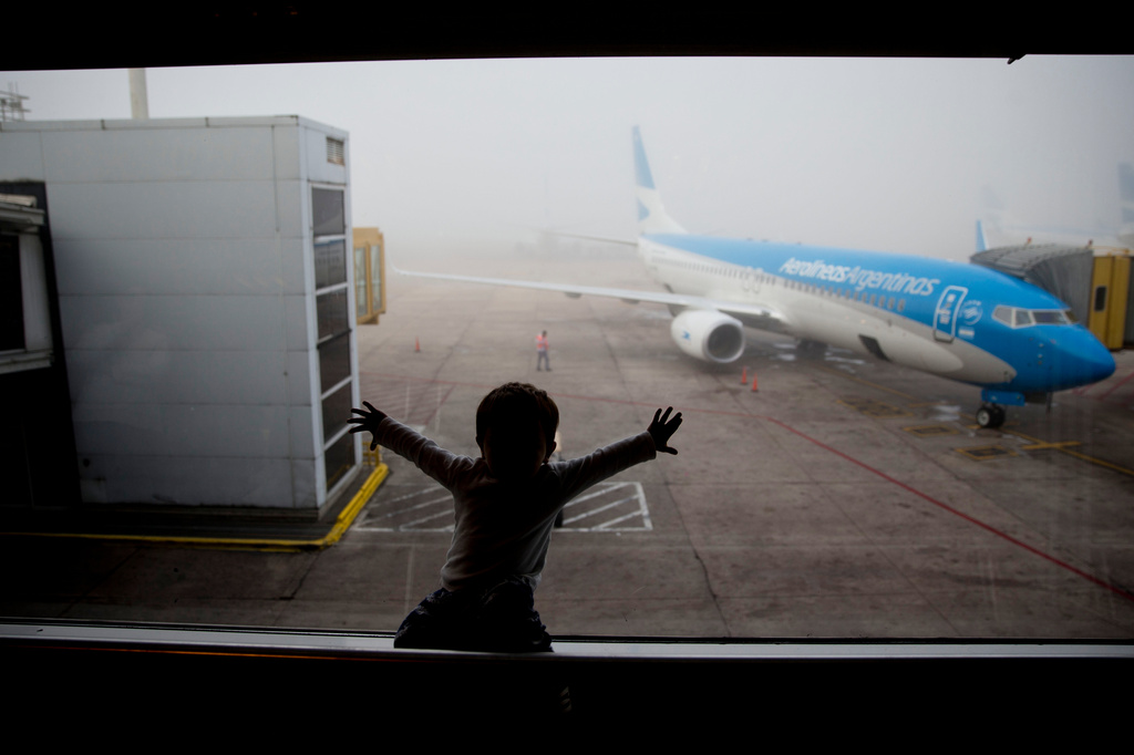 FILE - A child watches a plane at the Jorge Newbery airport in Buenos Aires, Argentina, April 14, 2016. (AP Photo/Natacha Pisarenko, File)