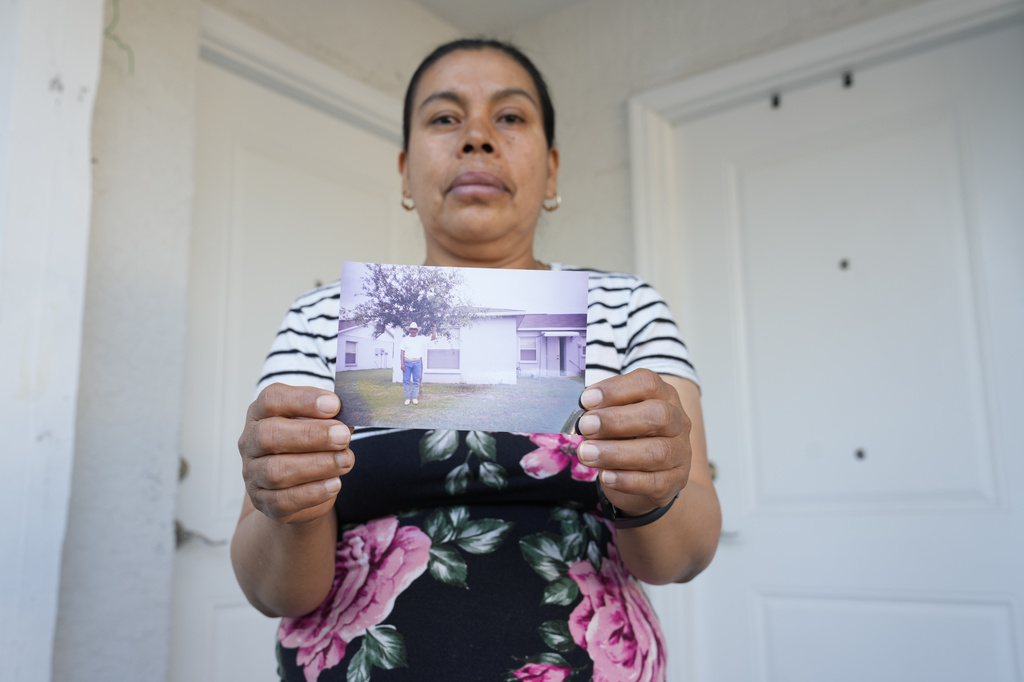 Maria Jose Gonzalez holds a photo of her husband, Jose-Antonio Segismundo, who was detained for six months at "Alligator Alcatraz," April 16, 2026, in Wimauma, Fla. (AP Photo/Chris O'Meara)