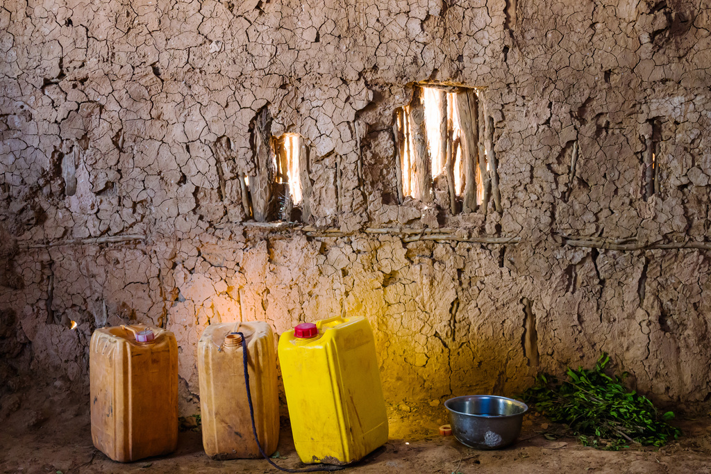 Yellow jerrycans, for hauling water, sit next to a bowl for washing up and a pile of khat leaves Friday, Jan. 9, 2026, in Sanqotor, Ethiopia. (AP Photo/Julianne Gauron)