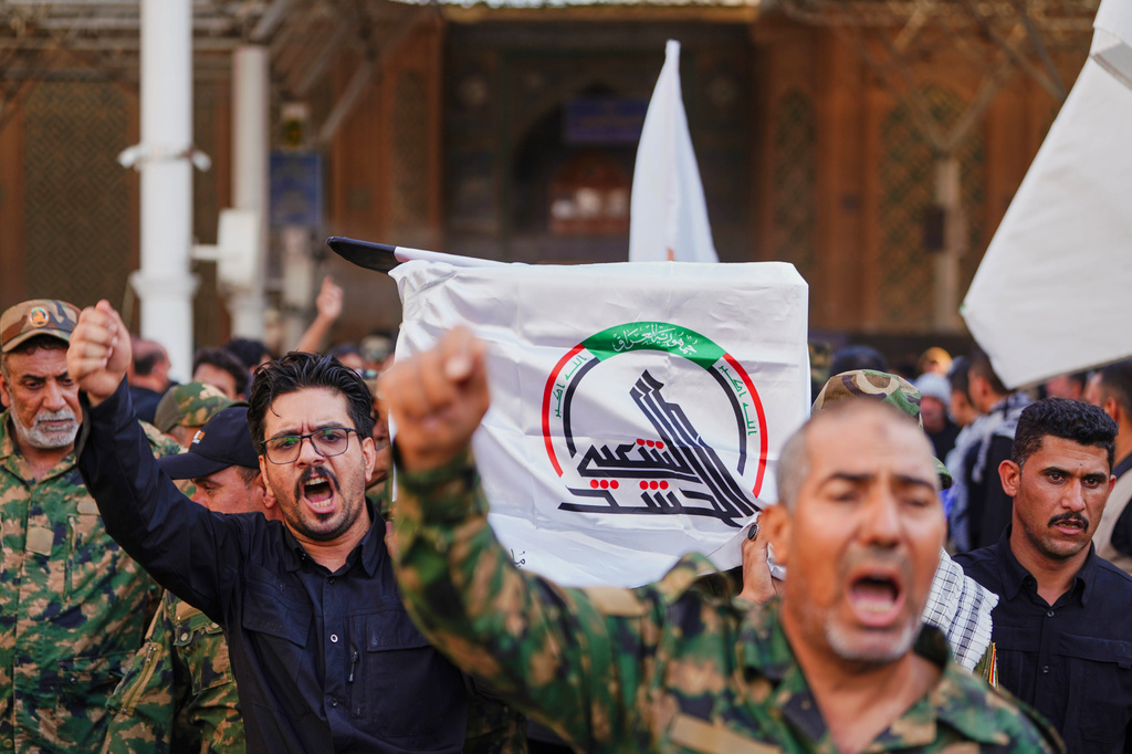 Mourners carry a coffin draped with a cloth bearing the emblem of Iraq's Popular Mobilization Forces during a funeral for Popular Mobilization Forces fighters killed in airstrikes on PMF bases in Najaf, Iraq, Thursday, July 30, 2026. (AP Photo/Hadi Mizban)