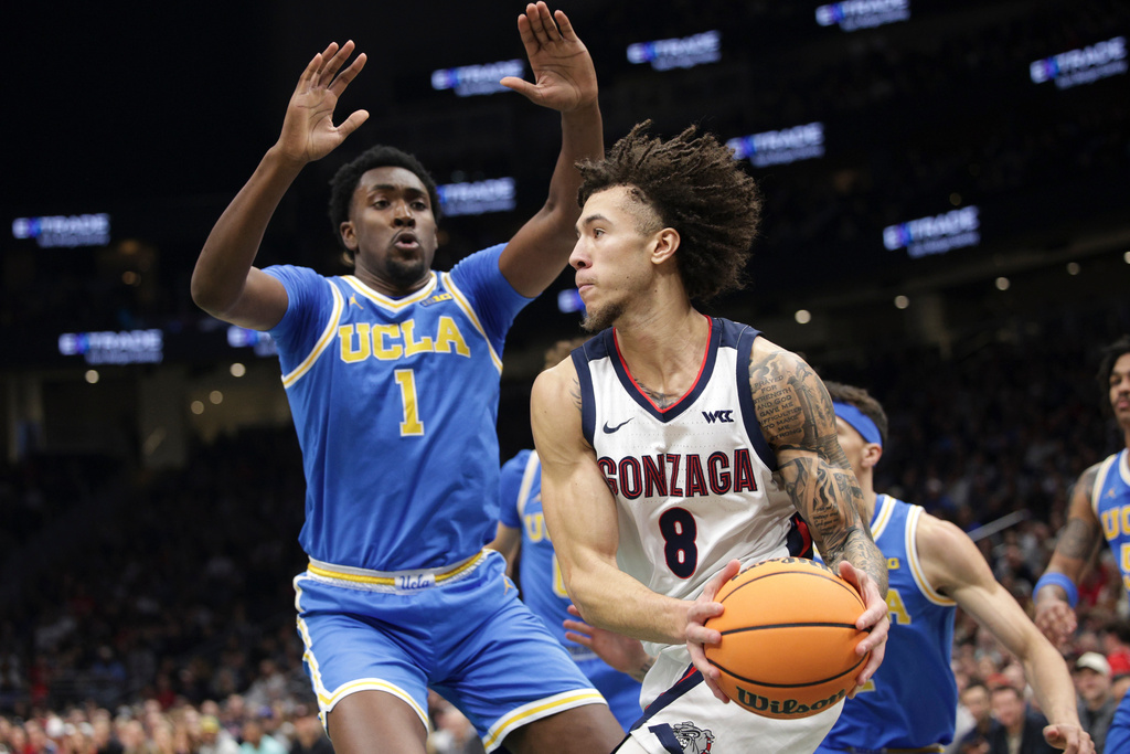 Gonzaga guard Jalen Warley (8) drives as UCLA forward/center Xavier Booker (1) defends during the first half of a NCAA basketball game, Saturday, Dec. 13, 2025, in Seattle. (AP Photo/Jason Redmond)