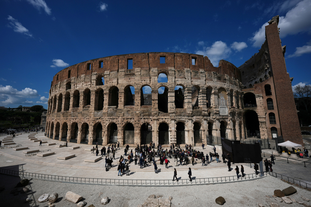 People walk in the new outdoor space created with travertine marble around the Colosseum during it's inauguration in Rome, Tuesday, March 17, 2026. (AP Photo/Andrew Medichini)