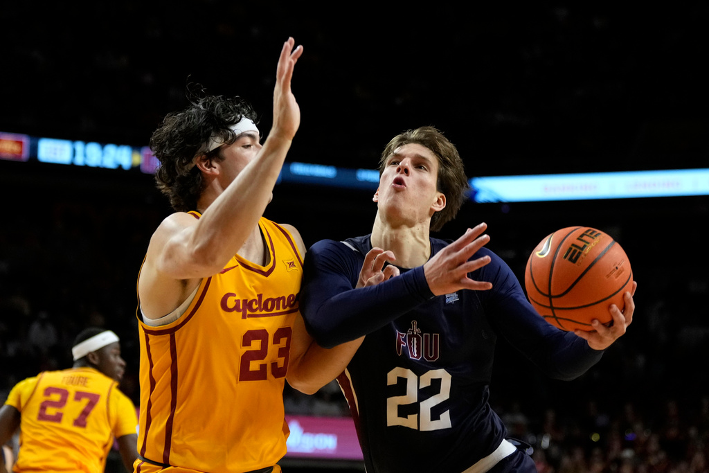 Fairleigh Dickinson center Cyril Martynov (22) drives to the basket past Iowa State forward Blake Buchanan (23) during the first half of an NCAA college basketball game, Monday, Nov. 3, 2025, in Ames, Iowa. (AP Photo/Charlie Neibergall)