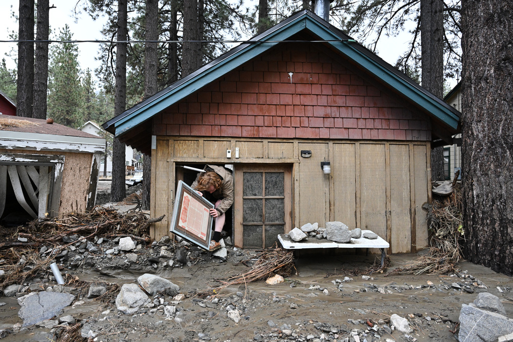 Davey Schneider recovers items from his storm damaged home on Thursday, Dec. 25, 2025, in Wrightwood, Calif. (AP Photo/William Liang)