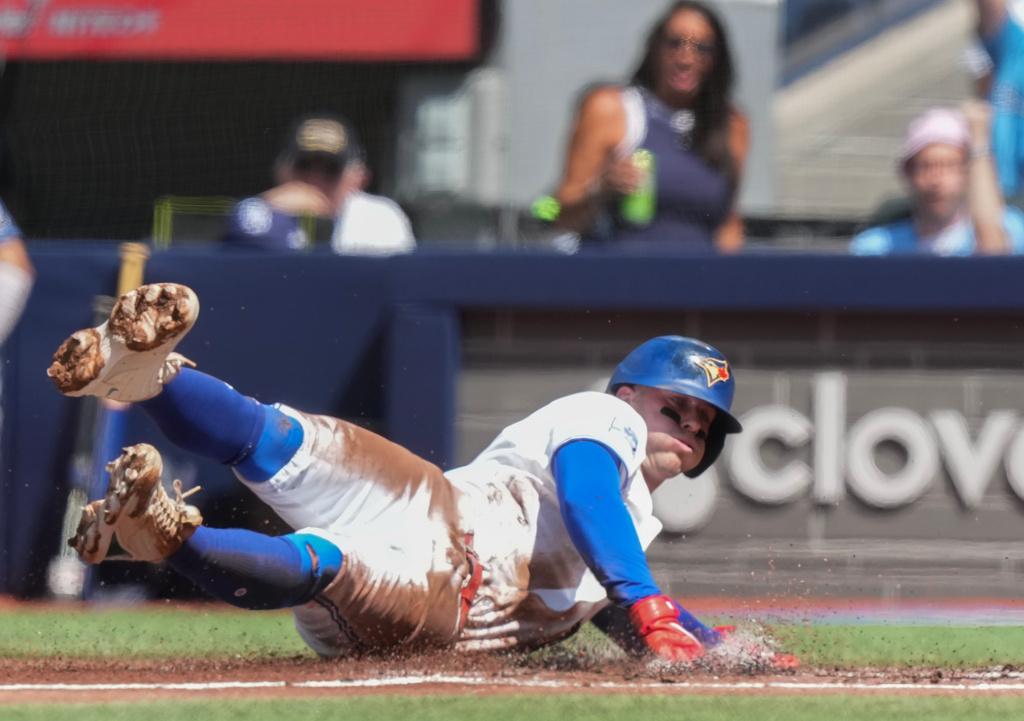 Toronto Blue Jays' Ernie Clement slides safely in to home to score against the Tampa Bay Rays during the first inning of a baseball game in Toronto, Thursday, July 23, 2026. (Nathan Denette/The Canadian Press via AP)