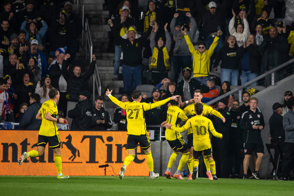 Columbus Crew midfielder Dylan Chambost, back right, celebrates with defender Steven Moreira (31) and forward Diego Rossi (10) after scoring on a penalty kick during the first half of Game 2 in the first round of MLS soccer's Eastern Conference playoffs against FC Cincinnati, Sunday, Nov. 2, 2025, in Columbus. (AP Photo/Tanner Pearson)