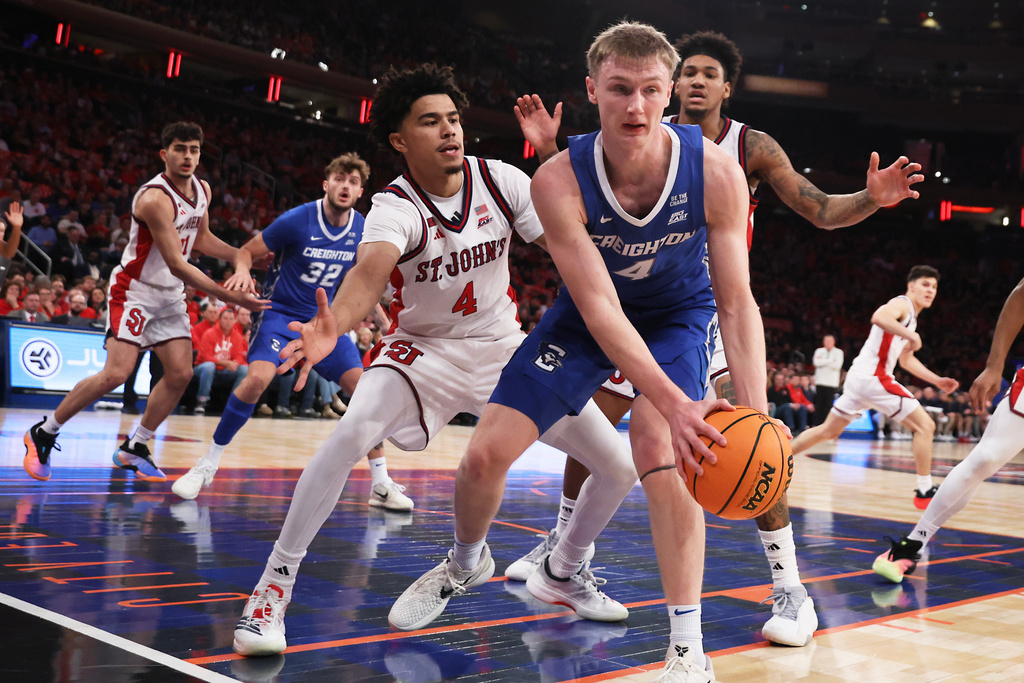 Creighton guard Josh Dix (4) is defended by St. John's guard Oziyah Sellers (4) and St. John's forward Dillon Mitchell during the first half of an NCAA college basketball game, Saturday, Feb. 21, 2026, in New York. (AP Photo/Heather Khalifa)