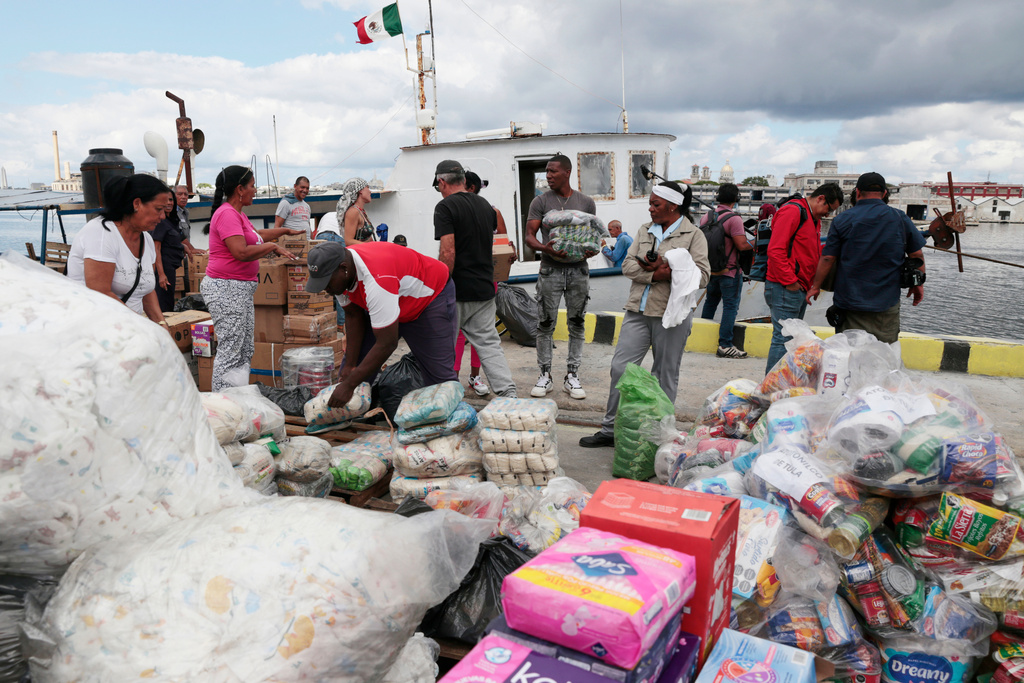 Activists from the vessel Maguro that arrived from Mexico, behind, as part of the "Nuestra America," or Our America convoy, unload humanitarian aid with the help of Cuban port workers in Havana Bay, Cuba, Tuesday, March 24, 2026. (Jorge Luis Banos/IPS via AP, Pool)