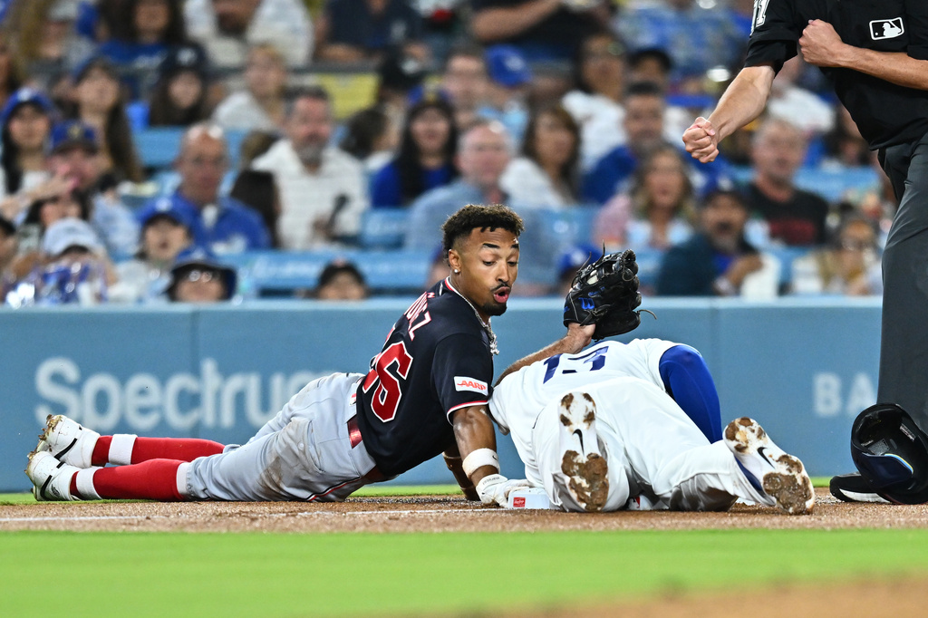 Washington Nationals' Nasim Nuñez, left, is caught by Los Angeles Dodgers third baseman Max Muncy (13) while trying to steal third base during the third inning of a baseball game Friday, Sept. 4, 2026, in Los Angeles. (AP Photo/William Liang)