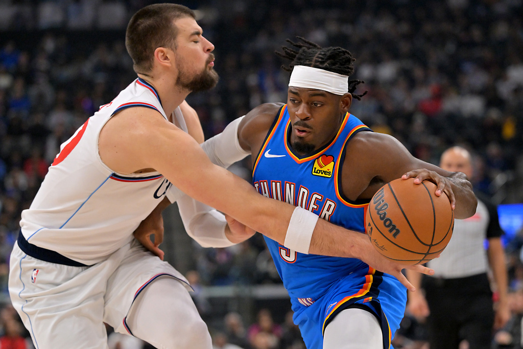 Los Angeles Clippers center Ivica Zubac, left, defends Oklahoma City Thunder guard Luguentz Dort as he drives to the basket during the first half of an NBA basketball game Tuesday, Nov. 4, 2025, in Los Angeles. (AP Photo/Jayne Kamin-Oncea)
