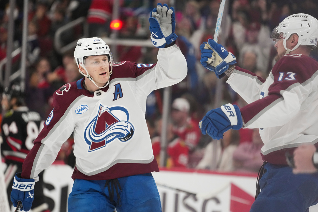 Colorado Avalanche center Nathan MacKinnon, left, and right wing Valeri Nichushkin (13) celebrate after a goal by center Martin Necas during the first period of an NHL hockey game against the Chicago Blackhawks, Friday, March 20, 2026, in Chicago. (AP Photo/Erin Hooley)
