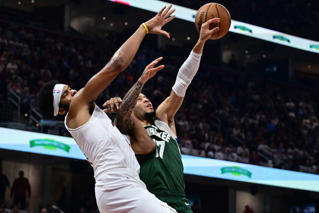 Milwaukee Bucks guard Amir Coffey, right, knocks the ball away from Cleveland Cavaliers center Jarrett Allen, left, in the first half of an NBA basketball game Sunday, Oct. 26, 2025, in Cleveland. (AP Photo/David Dermer)