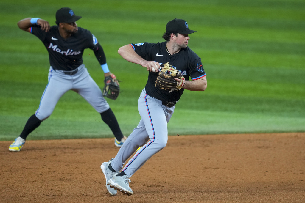 Miami Marlins second baseman Graham Pauley, right, fields a groundout by Texas Rangers' Josh Smith as teammate shortstop Otto Lopez mimics the motion during the sixth inning of a baseball game Friday, Sept. 19, 2025, in Arlington, Texas. (AP Photo/Julio Cortez)
