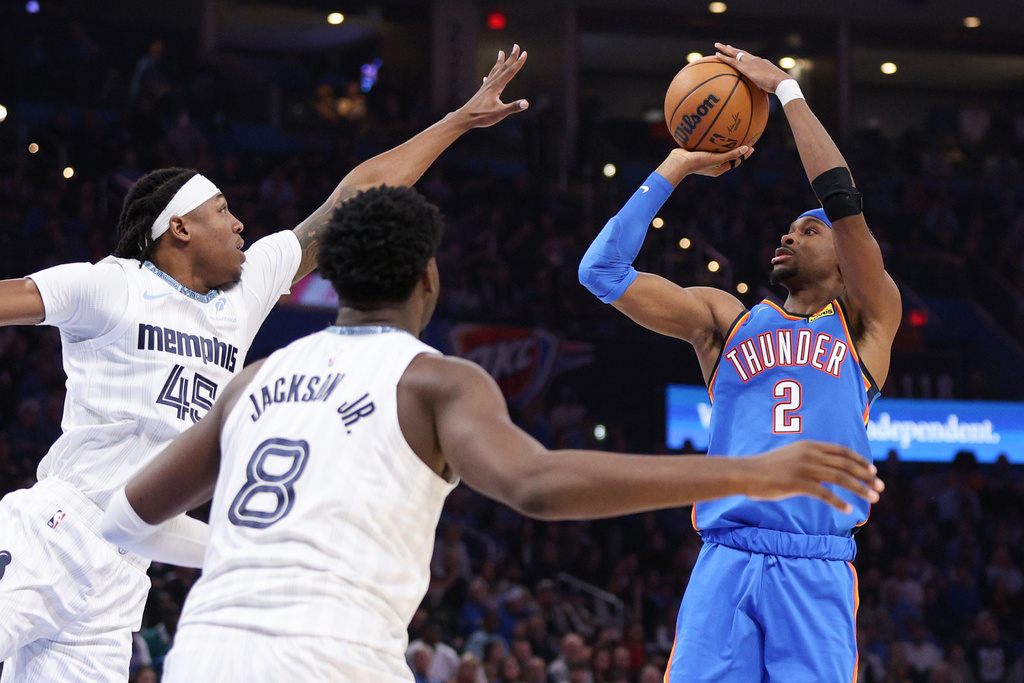 Oklahoma City Thunder guard Shai Gilgeous-Alexander (2) looks to shoot over Memphis Grizzlies forwards GG Jackson (45) and Jaren Jackson Jr. (8) during the second half of an NBA basketball game Monday, Dec. 22, 2025, in Oklahoma City. (AP Photo/Nate Billings)