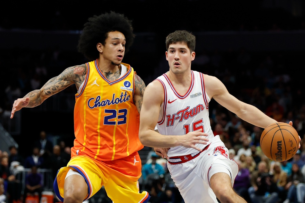 Houston Rockets guard Reed Sheppard, right, drives to the basket against Charlotte Hornets guard Tre Mann (23) during the first half of an NBA basketball game in Charlotte, N.C., Thursday, Feb. 19, 2026. (AP Photo/Nell Redmond)