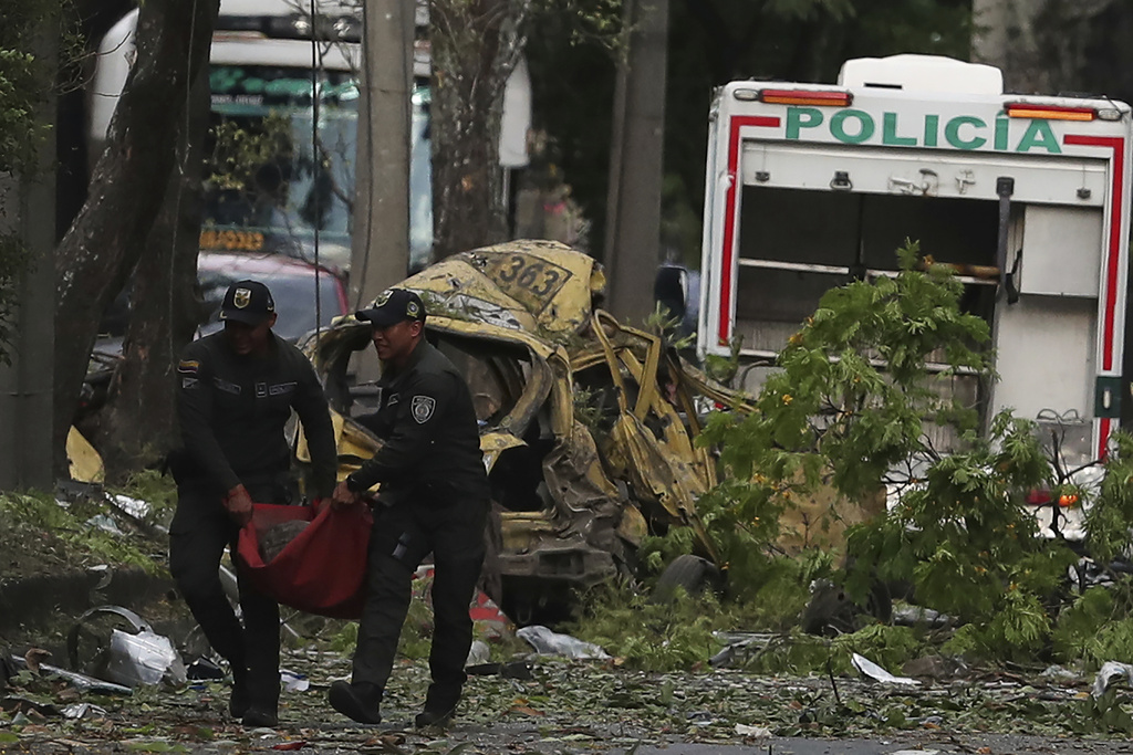 Police remove wreckage from the site of a bomb explosion outside an Air Force base in Cali, Colombia, Thursday, Aug. 21, 2025. (AP Photo/Santiago Saldarriaga)