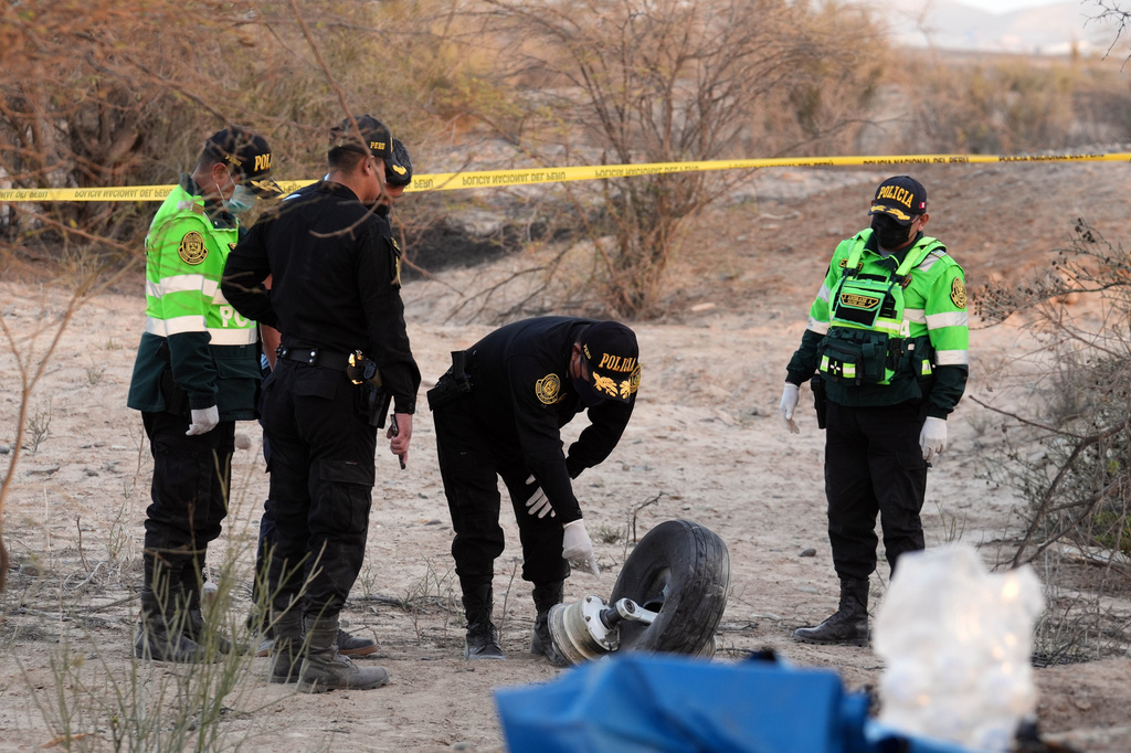 Police inspect the wreckage of a plane that crashed during a sightseeing flight carrying tourists over the Nazca Lines in Peru, Saturday, Aug. 1, 2026. (AP Photo/Genry Bautista)