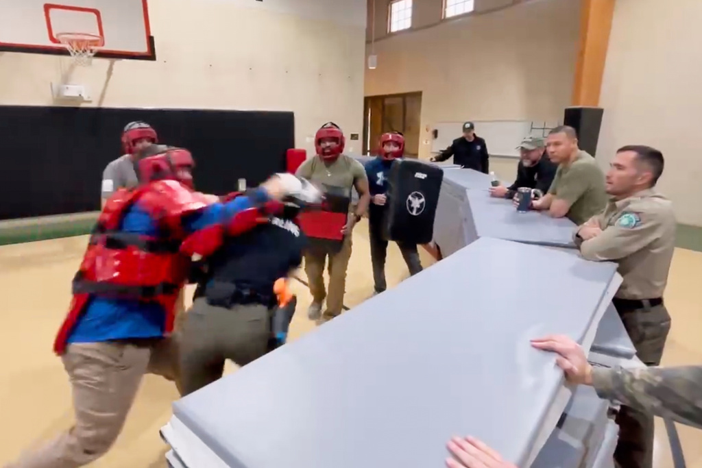 In this still image from video obtained by The Associated Press, Heather Sterling is hit in the head by one of her instructors, who is acting as a violent assailant, during a four-on-one training drill, Dec. 13, 2024, at the Texas Game Warden Training Center in Hamilton, Texas.