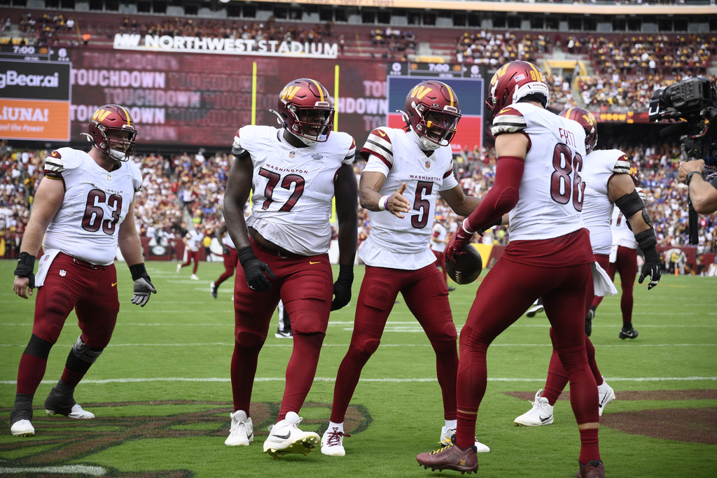 Washington Commanders tight end Zach Ertz (86) celebrating his touchdown with quarterback Jayden Daniels (5) and other teammates during the first half of an NFL football game against the New York Giants, Sunday, Sept. 7, 2025, in Landover, Md. (AP Photo/Nick Wass)