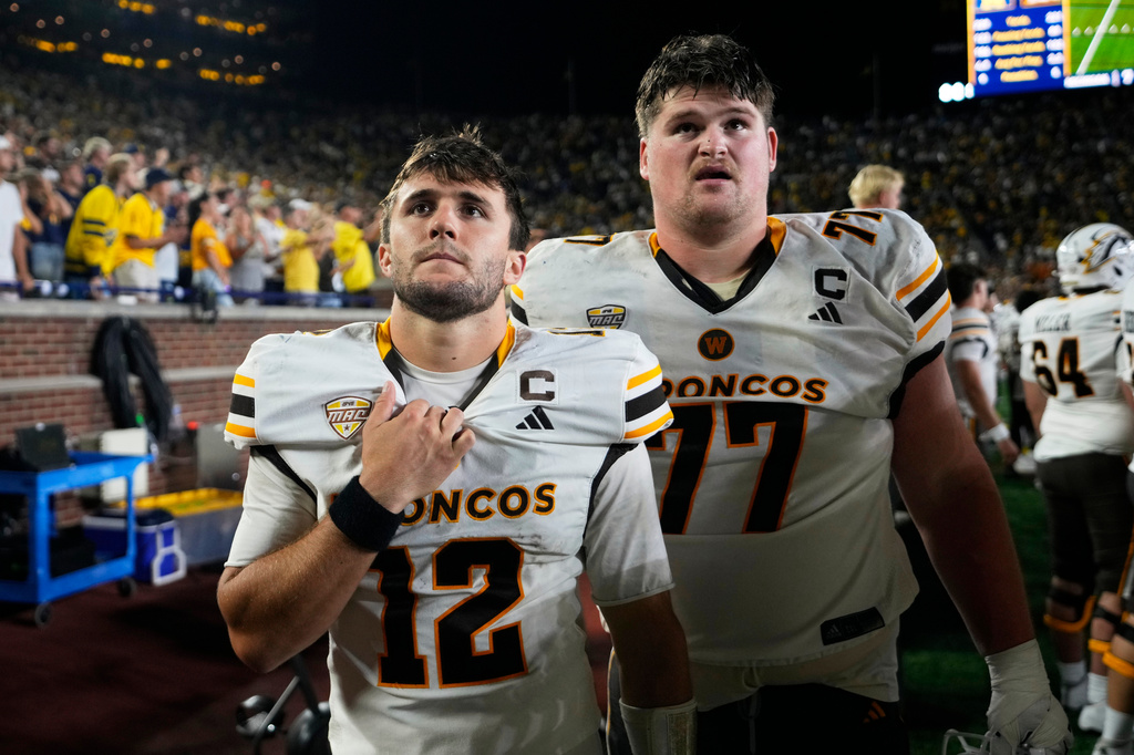 Western Michigan quarterback Broc Lowry (12) and Hunter Whitenack (77) watch from the bench at the end of the second half of an NCAA college football game against the Michigan Saturday, Sept. 5, 2026, in Ann Arbor, Mich. (AP Photo/Paul Sancya)