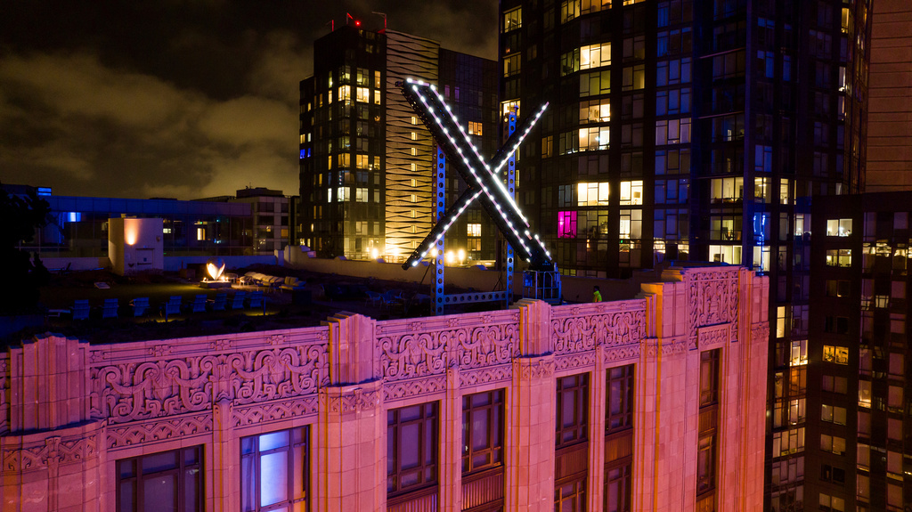 FILE - Workers install lights on an "X" sign atop the company headquarters in downtown San Francisco on July 28, 2023. (AP Photo/Noah Berger, File)