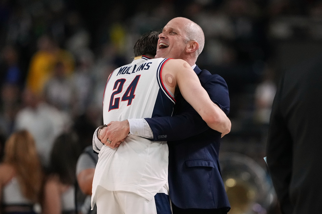 UConn's Braylon Mullins (24) and head coach Dan Hurley celebrate after defeating Illinois in an an NCAA college basketball tournament semifinal game at the Final Four, Saturday, April 4, 2026, in Indianapolis. (AP Photo/Michael Conroy)