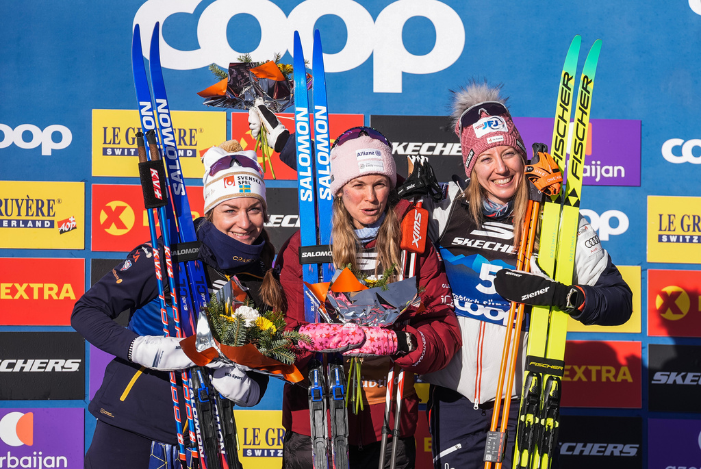 United States' Jessie Diggins, center, winner of the women's 20 km pursuit classic, part of the Tour de ski, cross-country skiing event, is flanked by second placed Sweden's Moa Ilar, left, and third placed Austria's Teresa Stadlober, in Dobbiaco, Italy, Thursday, Jan. 1, 2026. (Terje Pedersen/NTB Scanpix via AP)