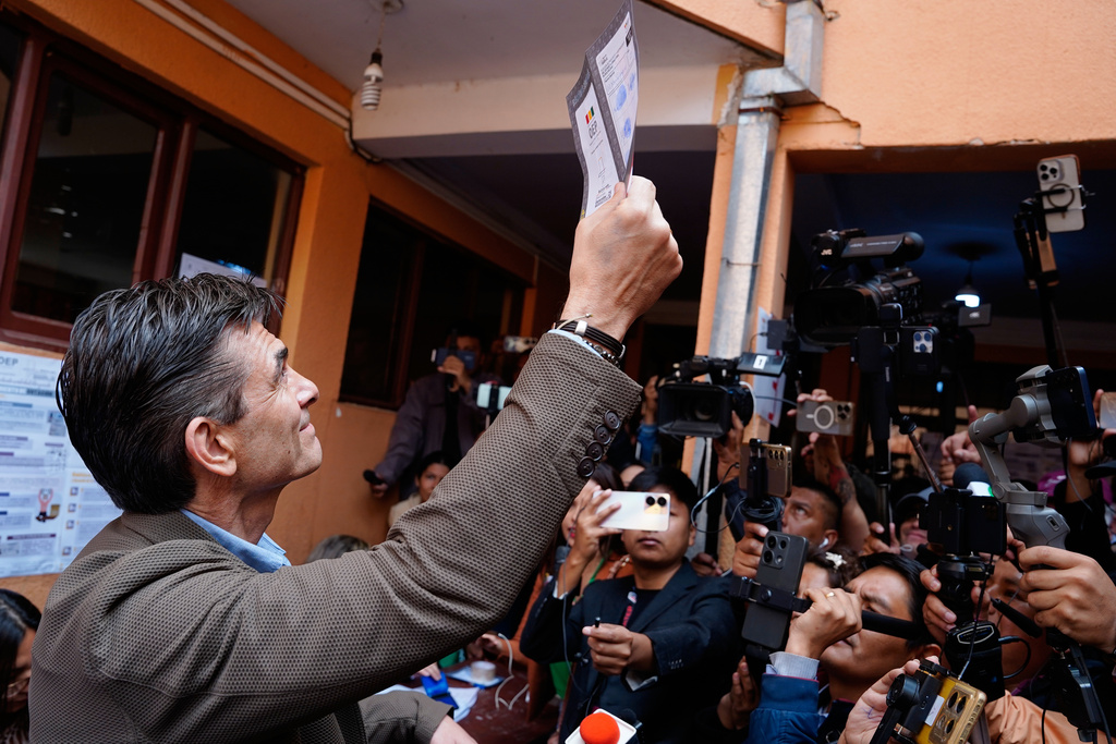 Presidential candidate Rodrigo Paz shows his ballot during the presidential runoff election in Tarija, Bolivia, Sunday, Oct. 19, 2025. (AP Photo/Freddy Barragan)