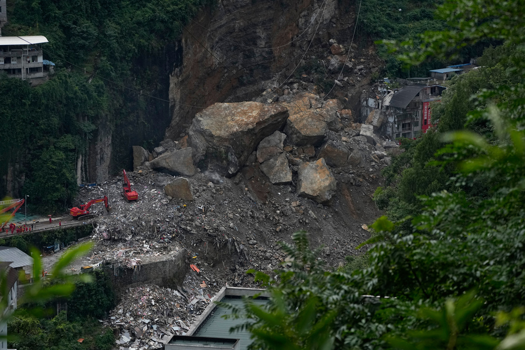 Rescuers use heavy machinery to clear rubble to search for trapped persons on the site of a landslide in Pengshui County, southwestern China's Chongqing on Sunday, July 19, 2026. (AP Photo/Andy Wong)