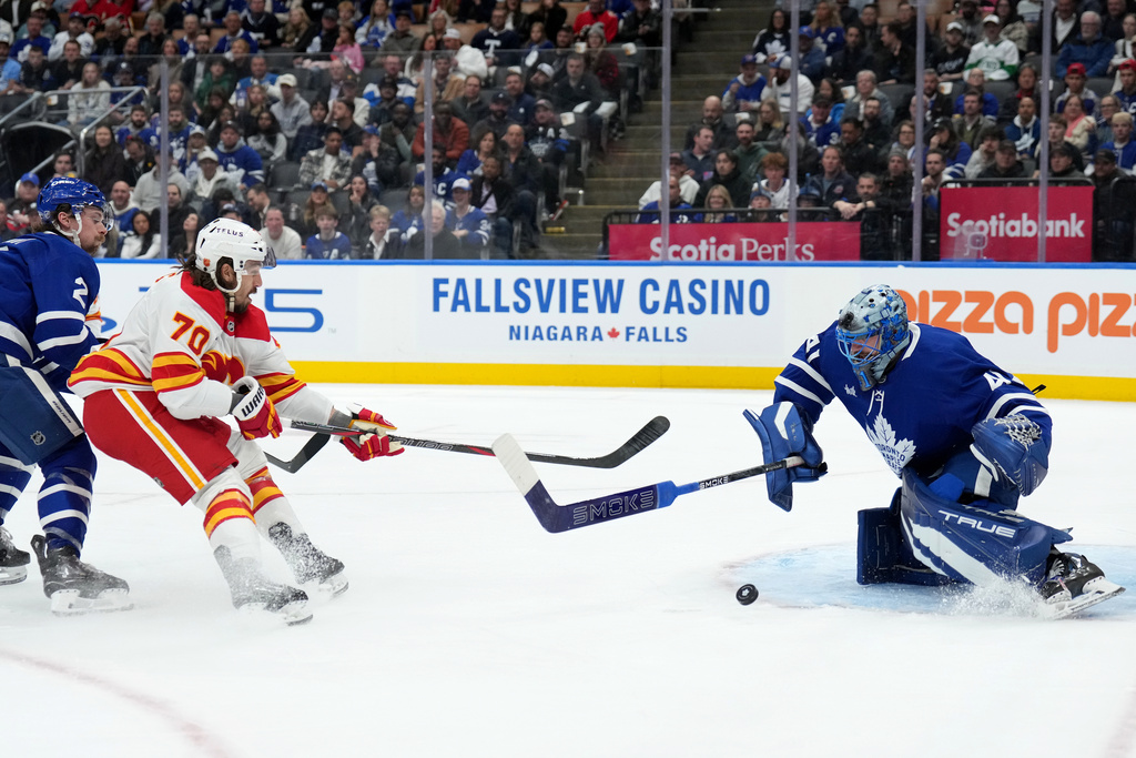 Toronto Maple Leafs goaltender Anthony Stolarz (41) poke checks Calgary Flames forward Ryan Lomberg (70) during third period NHL hockey action in Toronto, Tuesday, Oct. 28, 2025. T(Nathan Denette/The Canadian Press via AP)