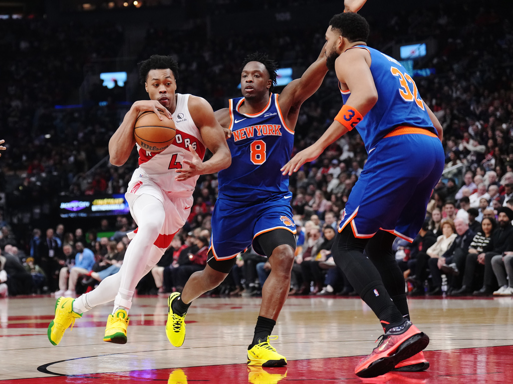 Toronto Raptors' Scottie Barnes (4) drives as New York Knicks' Og Anunoby (8) and Karl-Anthony Towns (32) defend during the first half of an NBA basketball game in Toronto on Tuesday, March 3, 2026. (Nathan Denette/The Canadian Press via AP)