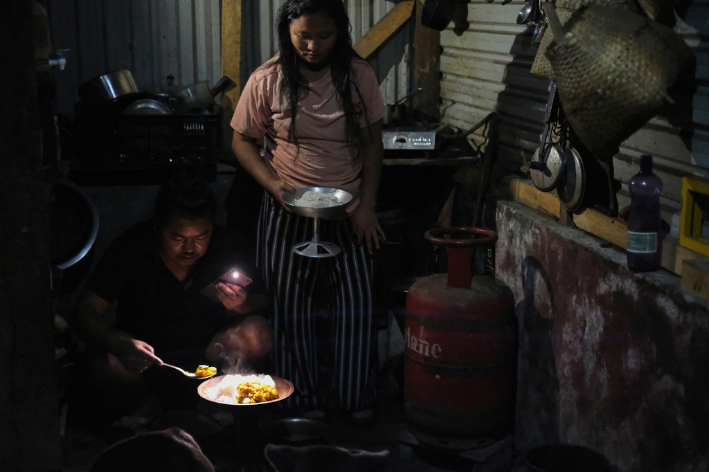 Tovi Murru, 32, and his wife Atoshi Ayemi serve food beside an empty liquefied petroleum gas cylinder inside their kitchen in Kohima, capital of the northeastern Indian state of Nagaland, Monday, July 6, 2026. (AP Photo/Yirmiyan Arthur)