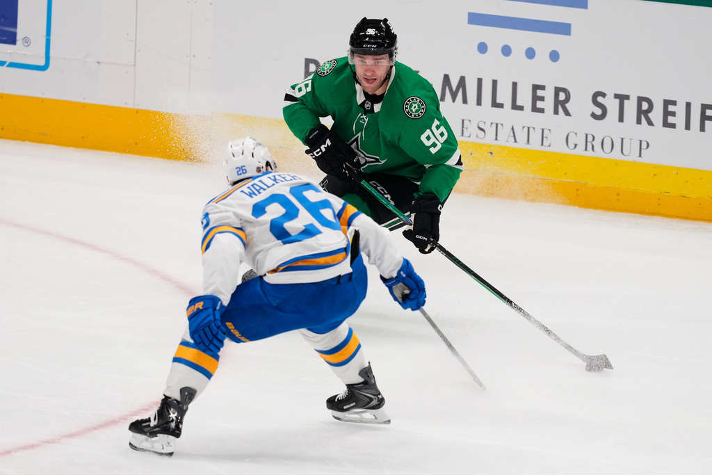 Dallas Stars right wing Mikko Rantanen (96) attempts to make a pass against St. Louis Blues left wing Nathan Walker (26) in the first period of an NHL hockey game Wednesday, Feb. 4, 2026, in Dallas. (AP Photo/Tony Gutierrez)