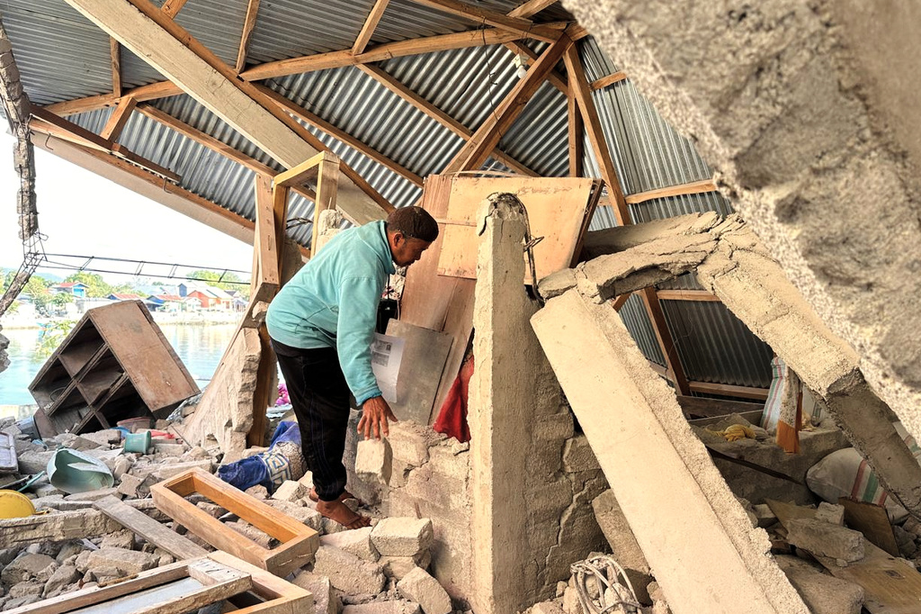 Arshad Hamid, an earthquake survivor, looks for valuables in his damaged house in North Lamba Leda, East Nusa Tenggara province, Indonesia, Wednesday, Aug. 19, 2026. (AP Photo/Firdia Lisnawati)
