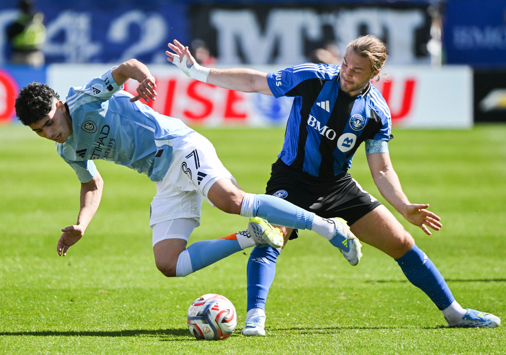 New York City FC's Arnau Farnos (87) is knocked off the ball by CF Montreal's Samuel Piette (6) during the first half of a MLS soccer game in Montreal, Saturday, April 25, 2026.(Graham Hughes/The Canadian Press via AP)