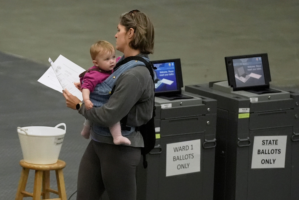 Lindsay Robinson, with daughter Scottie, walks to cast her ballots in the Maine Primary, Tuesday, June 9, 2026, in Augusta, Maine. (AP Photo/Robert F. Bukaty)