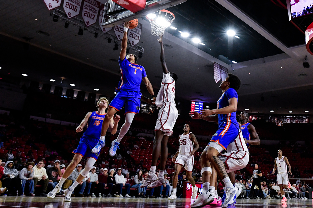 Florida guard Xaivian Lee (1) shoots against Oklahoma forward Kuol Atak (22) during the first half of an NCAA college basketball game, Tuesday, Jan. 13, 2026, in Norman, Okla. (AP Photo/Gerald Leong)