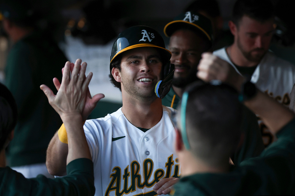 Athletics' Max Muncy, center, celebrates after scoring during the first inning of a home-opener baseball game against the Houston Astros, Friday, April 3, 2026, in West Sacramento, Calif. (AP Photo/Sara Nevis)