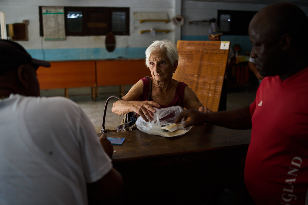 A woman receives a donation from Mexico at a state-run bodega during a blackout in Havana, Wednesday, March 4, 2026. (AP Photo/Ramon Espinosa)