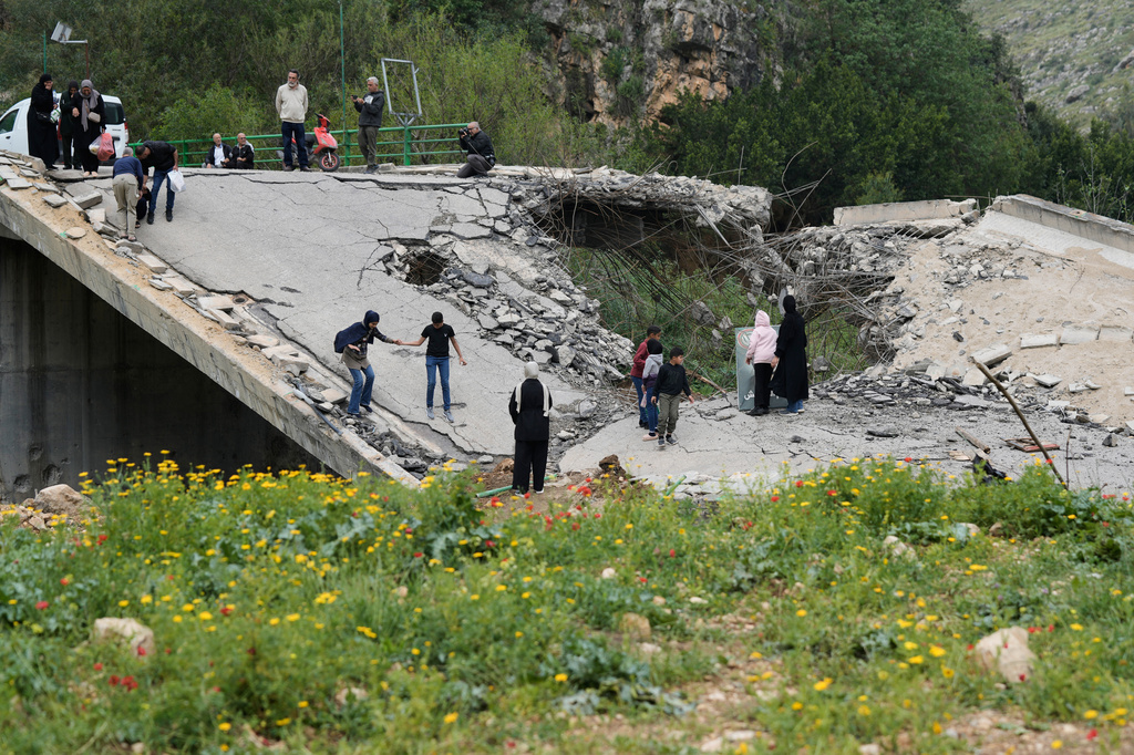 Displaced people cross on foot over a destroyed bridge as they return to their villages following a ceasefire between Hezbollah and Israel, in Tayr Felsay village near the city of Tyre, southern Lebanon, Sunday, April 19, 2026. (AP Photo/Bilal Hussein)