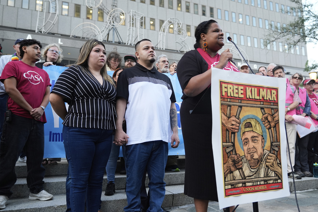 Jennifer Vasquez Sura, front left, and her husband Kilmar Abrego Garcia, front center, attend a protest rally at the Immigration and Customs Enforcement field office in Baltimore, Monday, Aug. 25, 2025, to support Kilmar Abrego Garcia. (AP Photo/Stephanie Scarbrough)