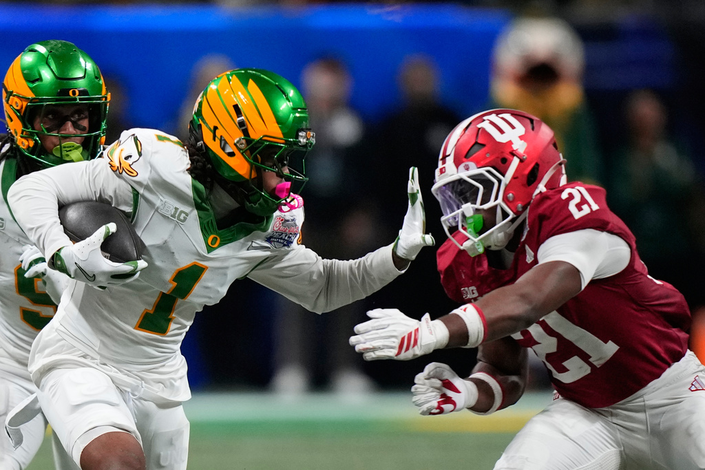 Oregon wide receiver Dakorien Moore (1) carries against Indiana linebacker Rolijah Hardy (21) during the second half of the Peach Bowl NCAA college football playoff semifinal, Friday, Jan. 9, 2026, in Atlanta. (AP Photo/Brynn Anderson)