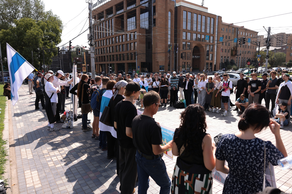 Russian citizens line up outside the Russian Embassy to join an anti-war demonstration to protest the ruling United Russia party and Moscow's ongoing invasion of Ukraine in Yerevan, Armenia, Sunday, Sept. 20, 2026, during the final day of Russia's parliamentary elections. (AP Photo/Anthony Pizzoferrato)