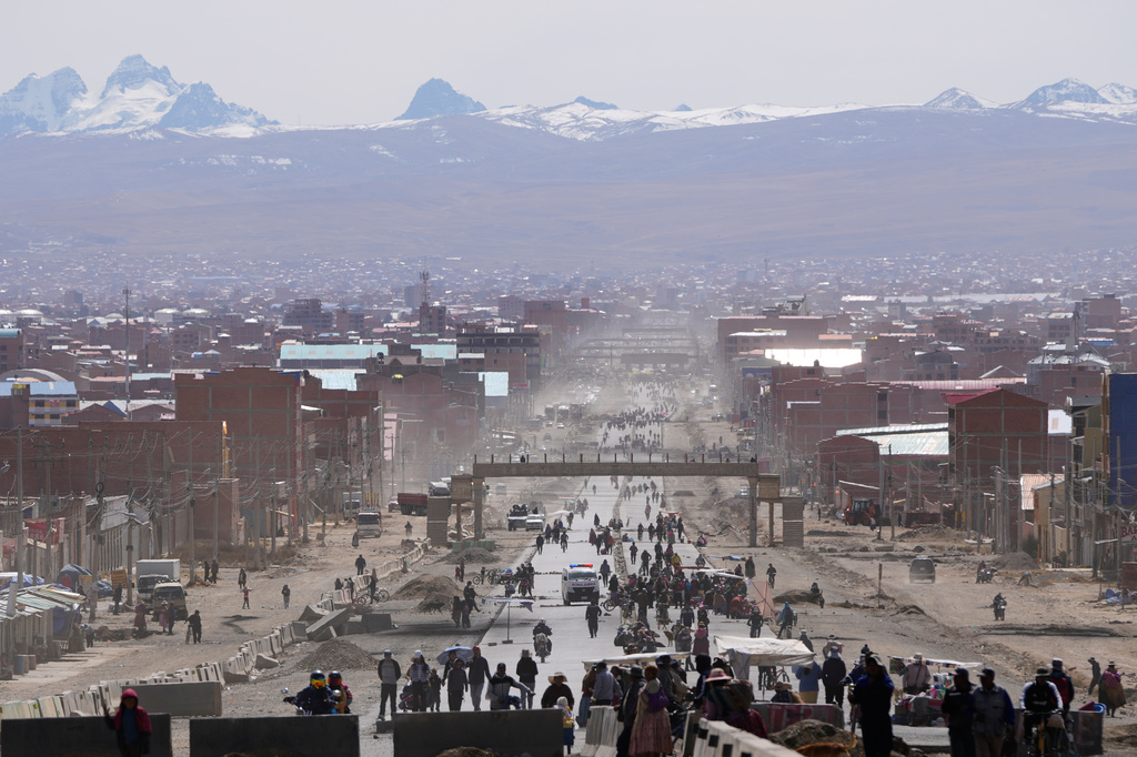 Residents walk on a highway after President Rodrigo Paz declared a state of emergency to empower the military to remove road blockades, in El Alto, Bolivia, Saturday, June 20, 2026. (AP Photo/Juan Karita)