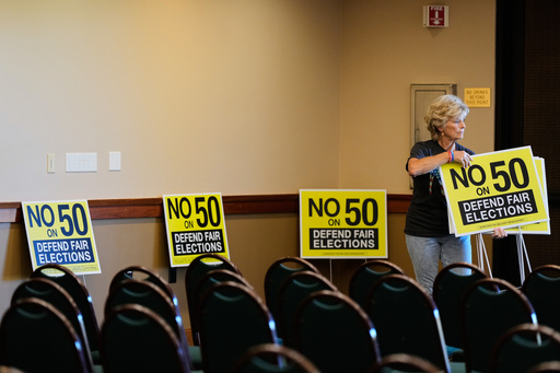 Brenda Haynes places signs throughout a conference room before a No on Prop 50 rally in Redding, Calif., Tuesday, Oct. 21, 2025. (AP Photo/Godofredo A. Vásquez) Brenda Haynes places signs throughout a conference room before a No on Prop 50 rally in Redding, Calif., Tuesday, Oct. 21, 2025. (AP Photo/Godofredo A. Vásquez)