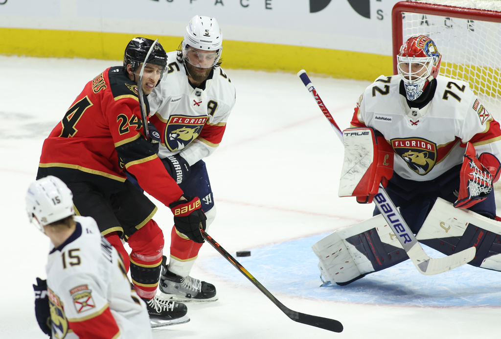 Ottawa Senators' Dylan Cozens (24) and Florida Panthers' Aaron Ekblad (5) battle for the puck in front of Panthers goaltender Sergei Bobrovsky (72) during second period NHL hockey action in Ottawa on Saturday, Jan. 10, 2026. (Patrick Doyle/The Canadian Press via AP)