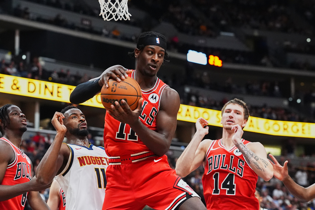 Chicago Bulls forward Leonard Miller, center, pulls in a rebound in front of forward Matas Buzelis, right, and Denver Nuggets guard Alpha Diallo in the second half of a preseason NBA basketball game Sunday, Oct. 11, 2026, in Denver. (AP Photo/David Zalubowski)