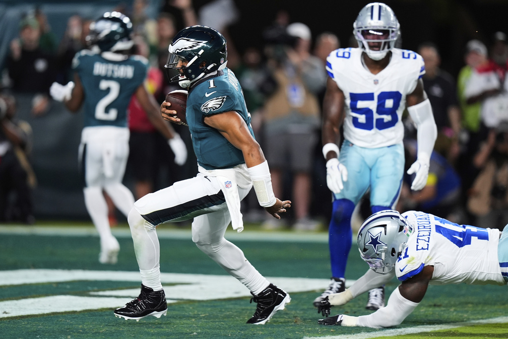 Philadelphia Eagles quarterback Jalen Hurts (1) runs the ball for a touchdown as after getting past Dallas Cowboys defensive end Donovan Ezeiruaku (41) in the first half of an NFL football game Thursday, Sept. 4, 2025, in Philadelphia. (AP Photo/Chris Szagola)